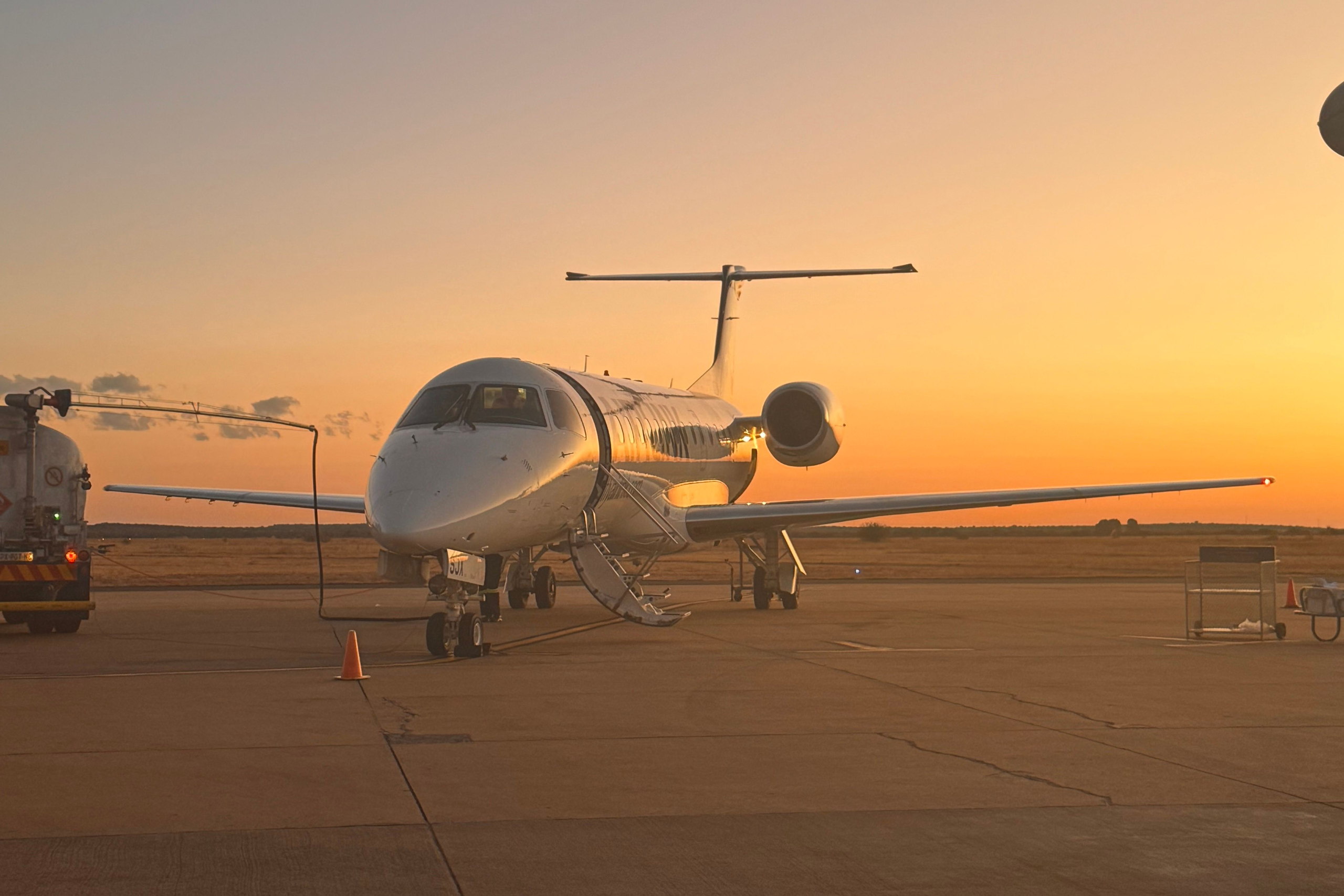 Business jet on an airport apron at sunset